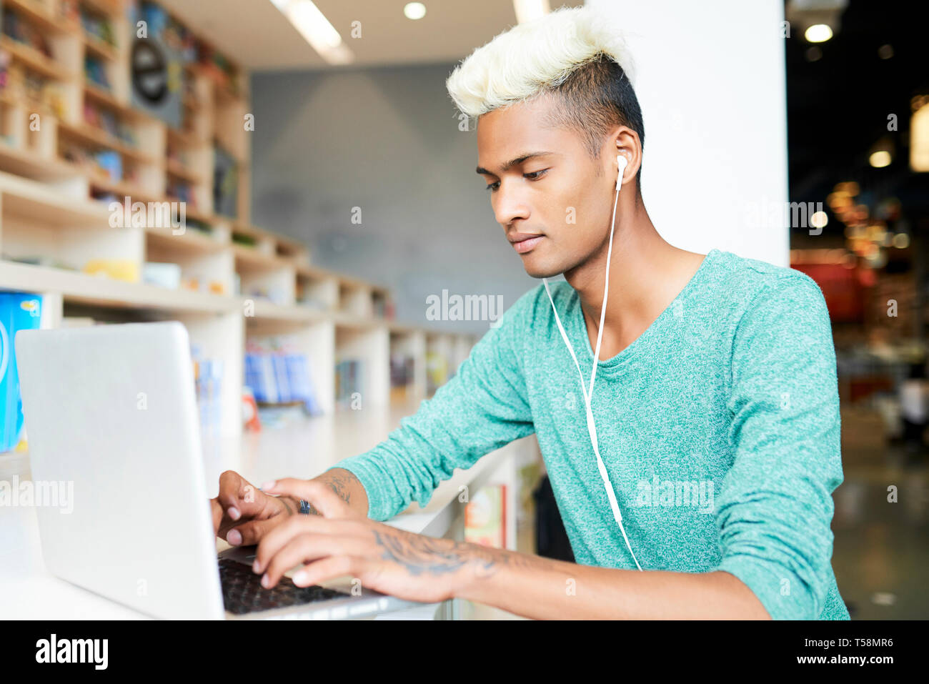 Gut aussehender student Tippen auf Laptop Stockfoto