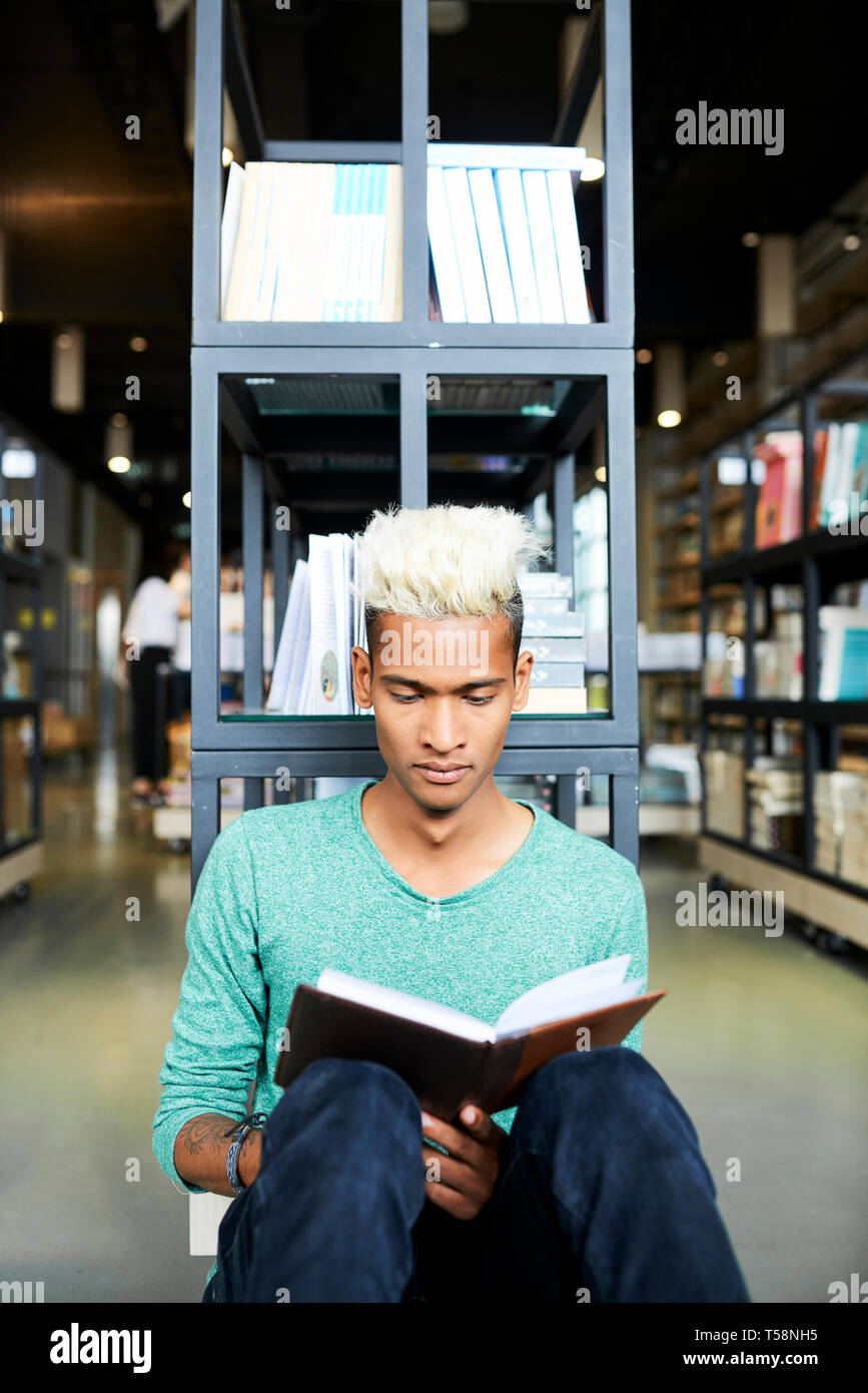 Neugierig schwarzen Studenten lesen Buch in der Bibliothek Stockfoto