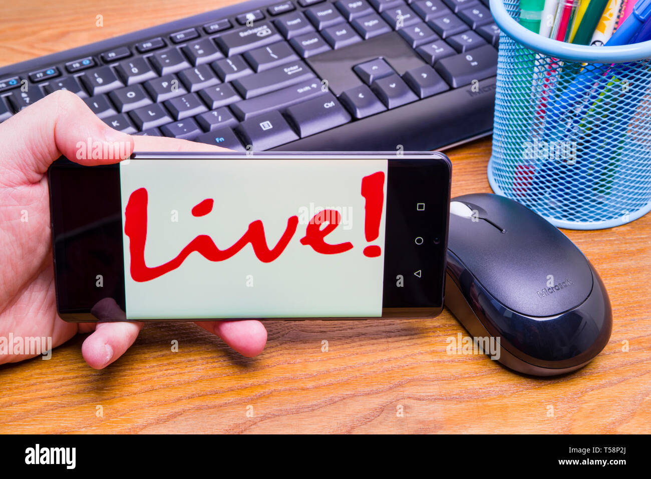 PIATRA Neamt, Rumänien - 13. APRIL 2019: Hand hält die neue Huawei Flaggschiff, P30 Pro, mit Live-Symbol auf dem Bildschirm, Büro Hintergrund. Stockfoto