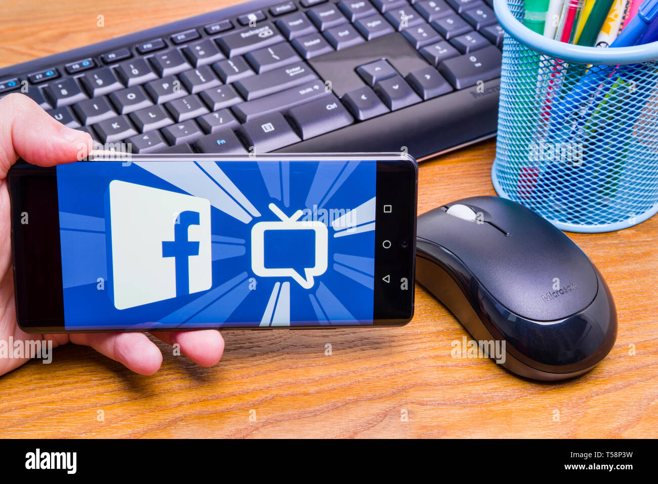 PIATRA Neamt, Rumänien - 13. APRIL 2019: Hand hält die neue Huawei Flaggschiff, P30 Pro, mit Facebook Watch auf dem Bildschirm, Büro Hintergrund. Stockfoto