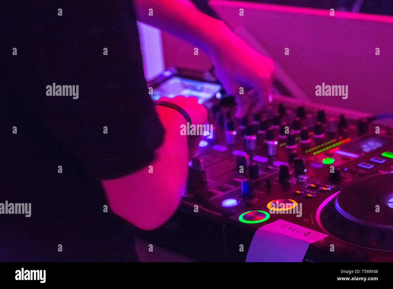 DJ auf Plattenspieler spielen elektronische Musik in dunklen Nachtclub in der Stadt Stockfoto