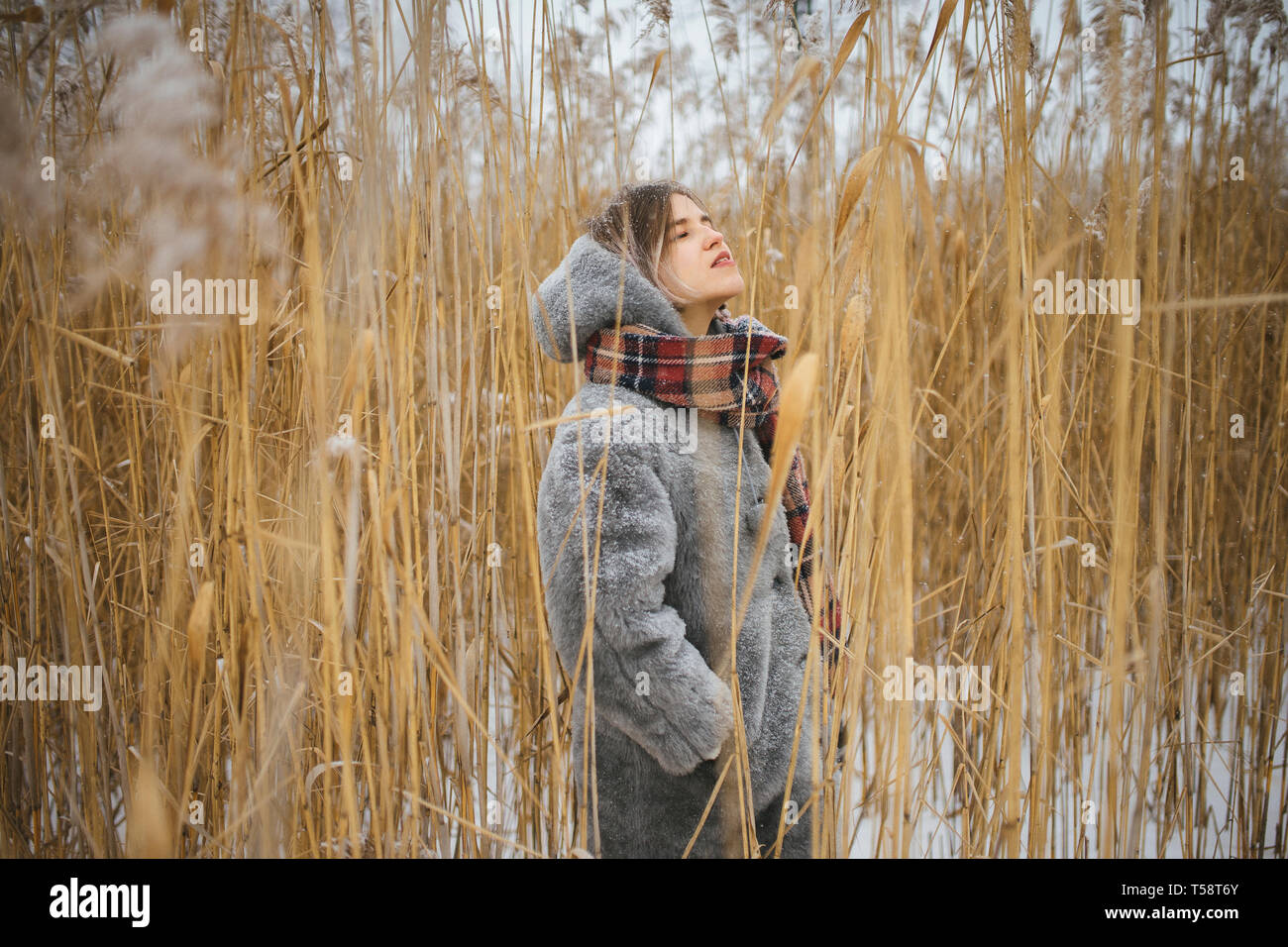Frau steht in der Mitte der Hohen trockenes Gras im Winter Stockfoto