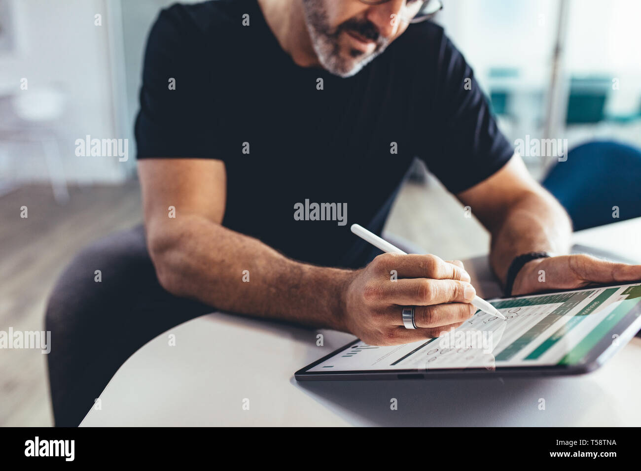 Geschäftsmann, der mit einem digitalen Stift an einem Tablet-pc arbeitet. Geschäftsmann, der den Finanzbericht auf seinem digitalen Tablet überprüft. Stockfoto