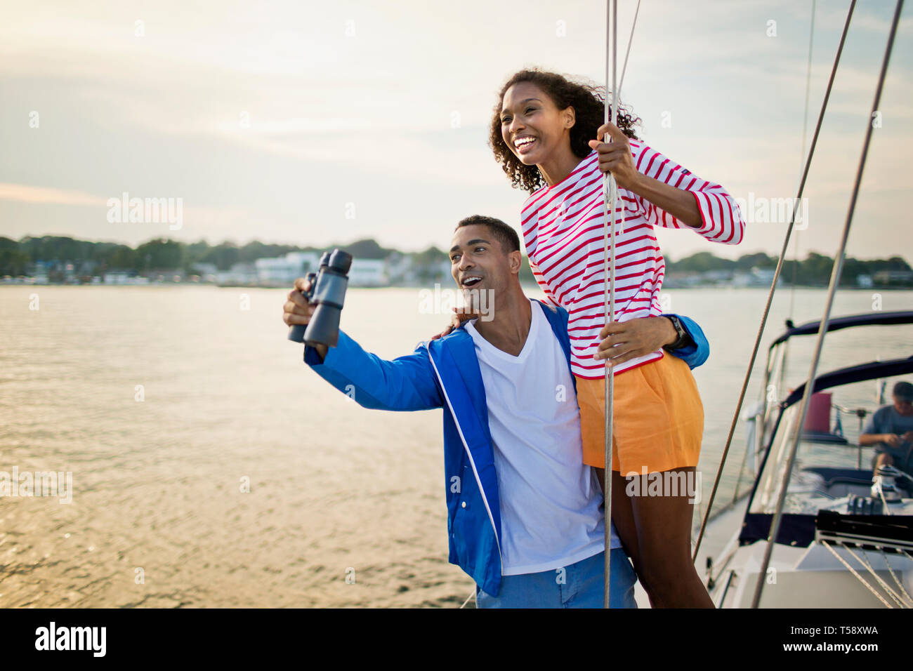 Glückliches junges Paar, das Spaß mit Fernglas beim Segeln. Stockfoto