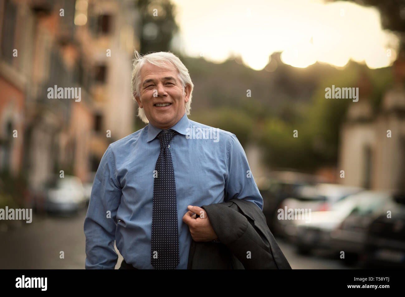 Porträt eines lächelnden reife Geschäftsmann zu Fuß von der Arbeit nach Hause. Stockfoto