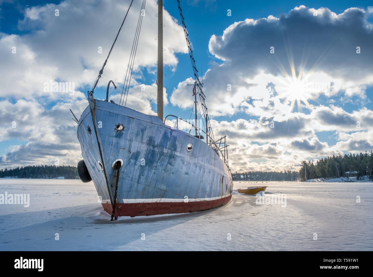 Alte und kaputte verlassenes Schiff auf Eis am sonnigen Wintertag in Küste Finnland. Stockfoto