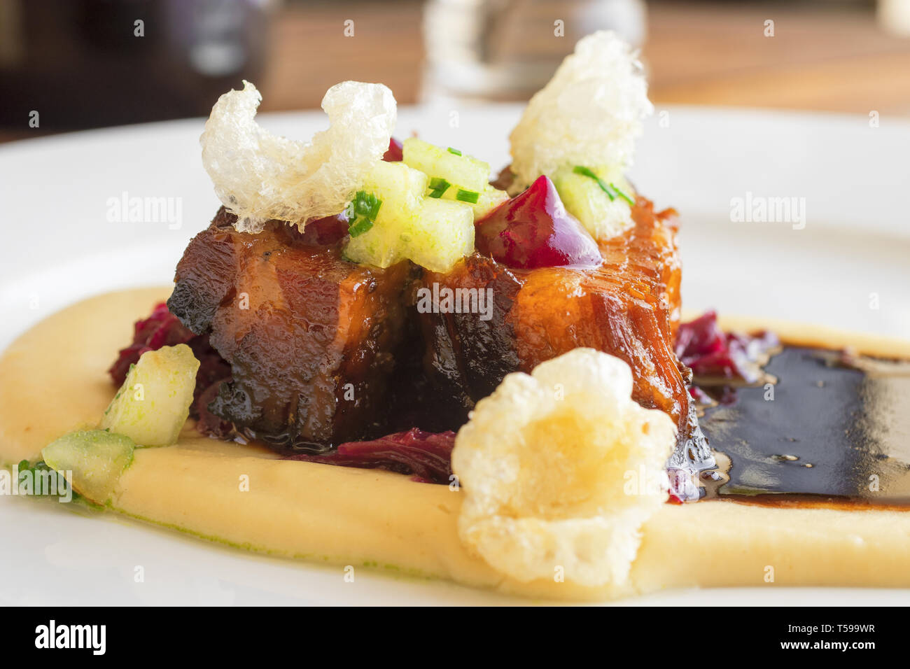 Hauptgericht, Teller mit gebratener Schweinebauch, rot Sauerkraut und Kartoffelbrei. Kochvorführungen. Stockfoto
