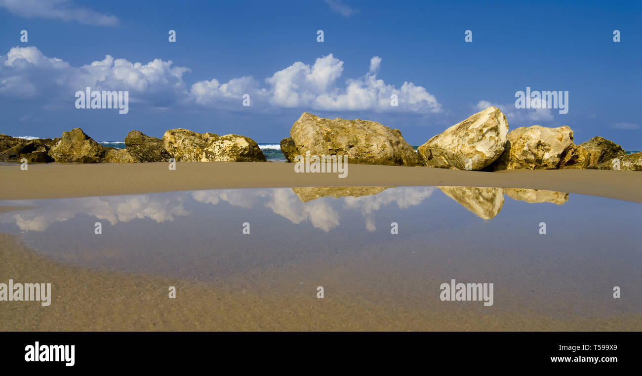 Linie der gelben Steine am Meer Sand im Wasser widerspiegelt Stockfoto