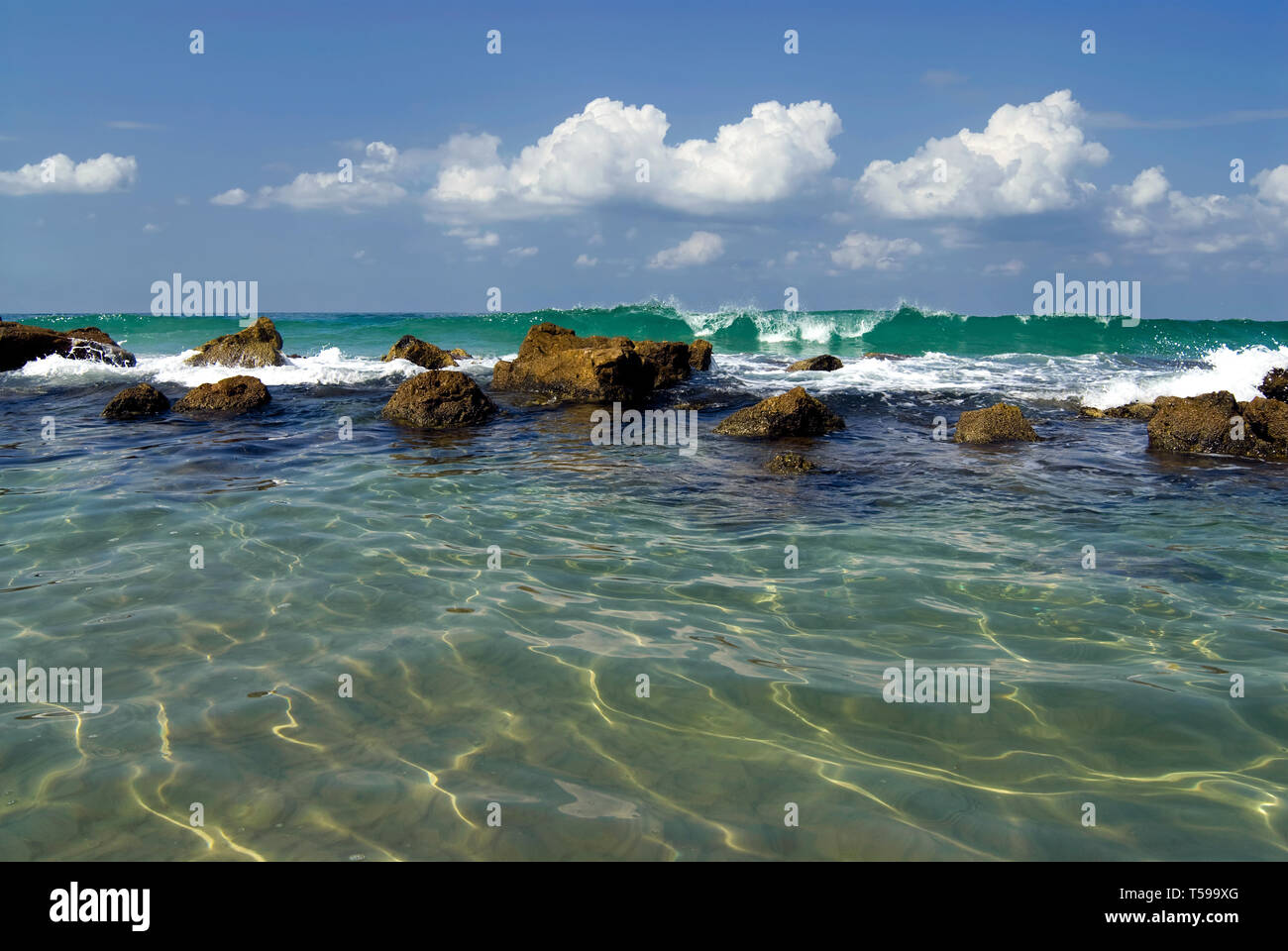 Sunlit flache Lagune von einem Meer von Felsen getrennt Stockfoto