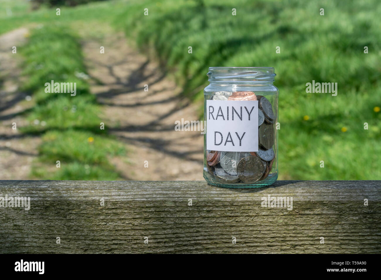 Geld jar/regnerischen Tag Einsparungen jar im Freien bei Sonnenschein. Metapher persönlichen Ersparnissen, Geld sparen, Vorsorge, Altersvorsorge, Speichern pot Stockfoto