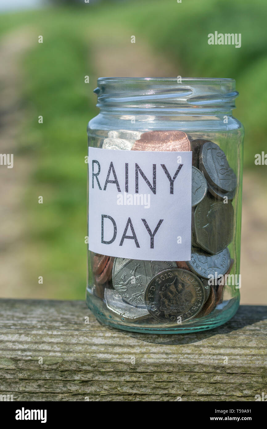Geld jar/regnerischen Tag Einsparungen jar im Freien bei Sonnenschein. Metapher persönlichen Ersparnissen, Geld sparen, Vorsorge, Altersvorsorge, Speichern pot Stockfoto