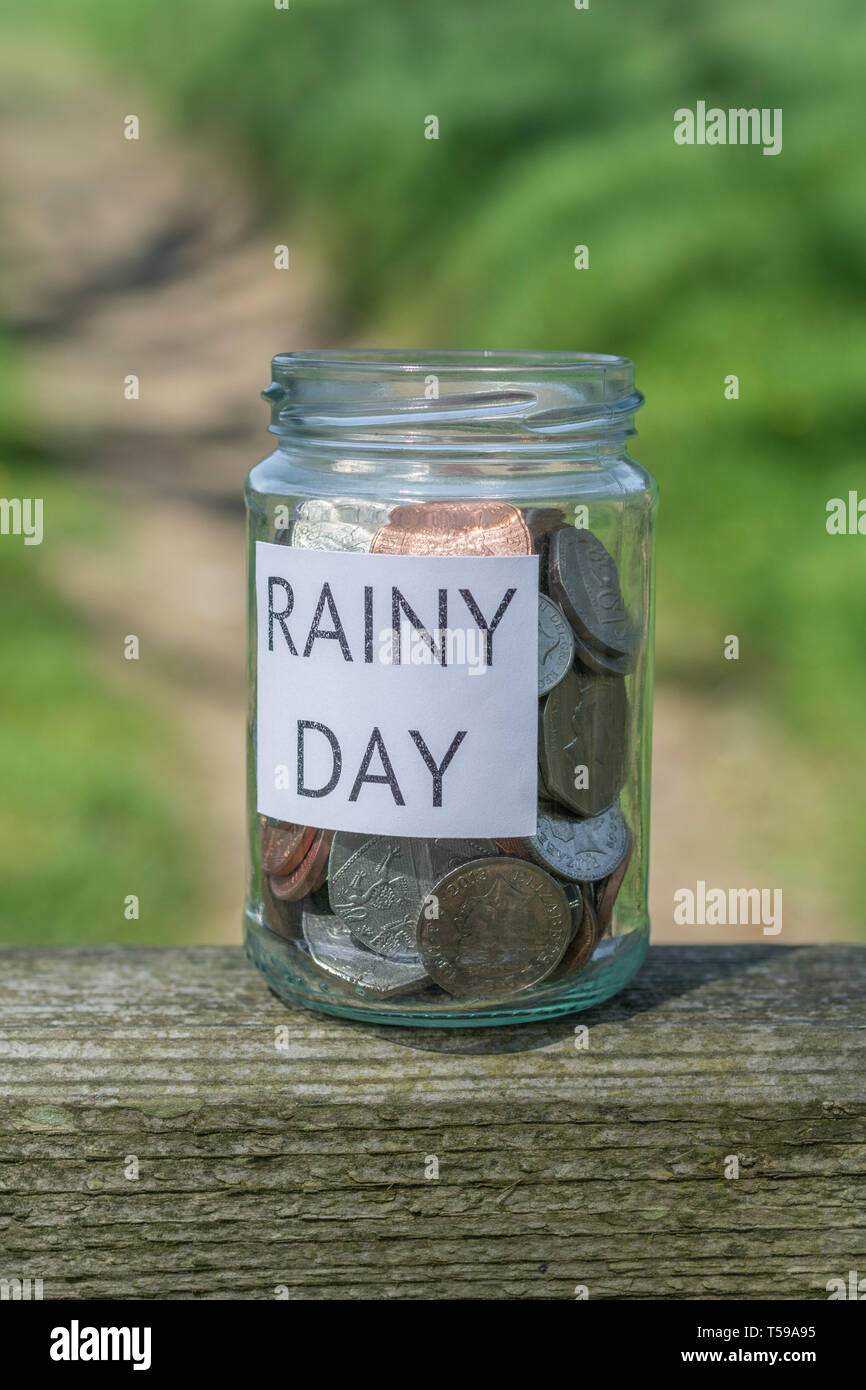 Geld jar/regnerischen Tag Einsparungen jar im Freien bei Sonnenschein. Metapher persönlichen Ersparnissen, Geld sparen, Vorsorge, Altersvorsorge, Speichern pot Stockfoto