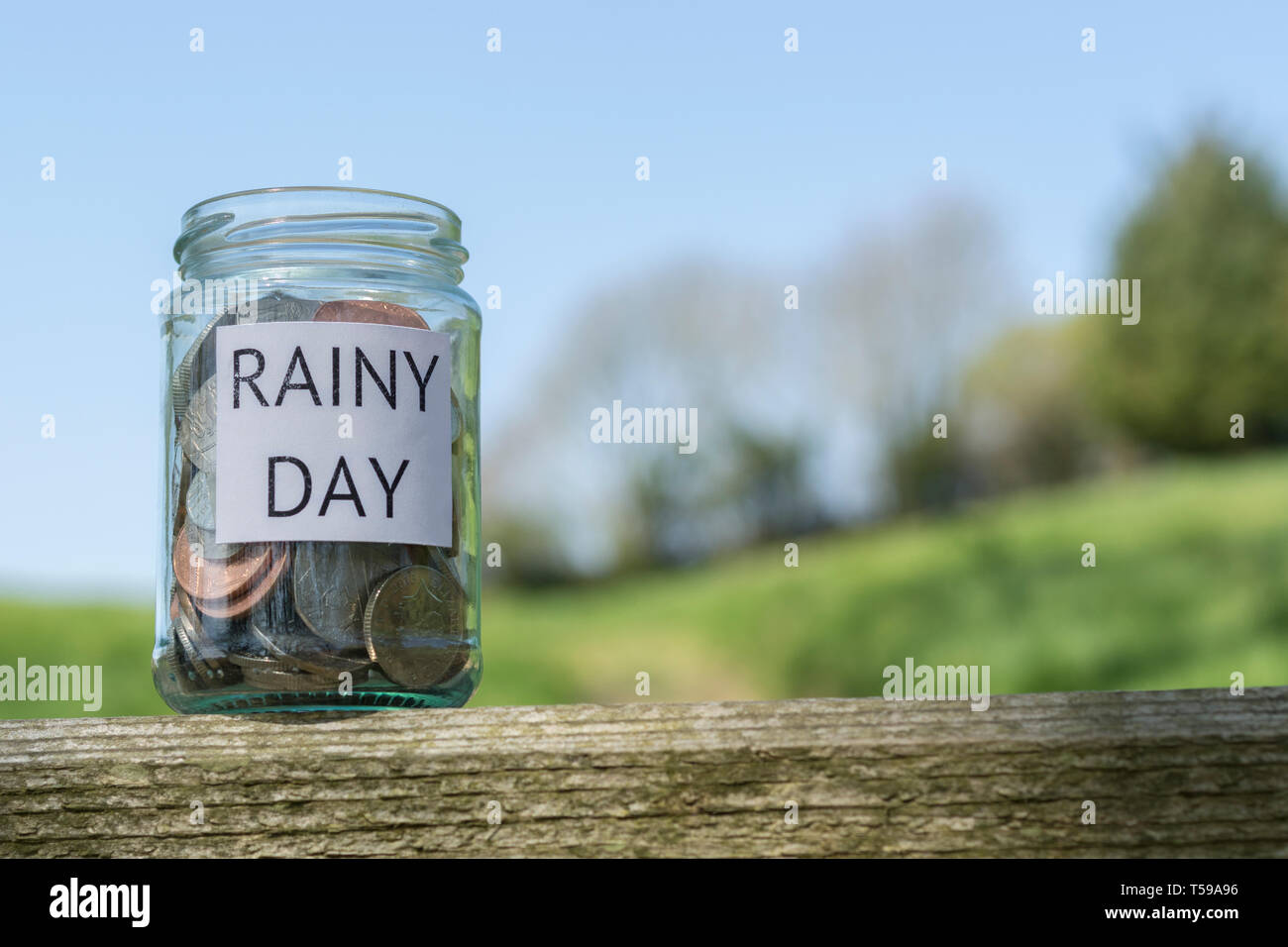 Geld jar/regnerischen Tag Einsparungen jar im Freien bei Sonnenschein. Metapher persönlichen Ersparnissen, Geld sparen, Vorsorge, Altersvorsorge, Speichern pot Stockfoto