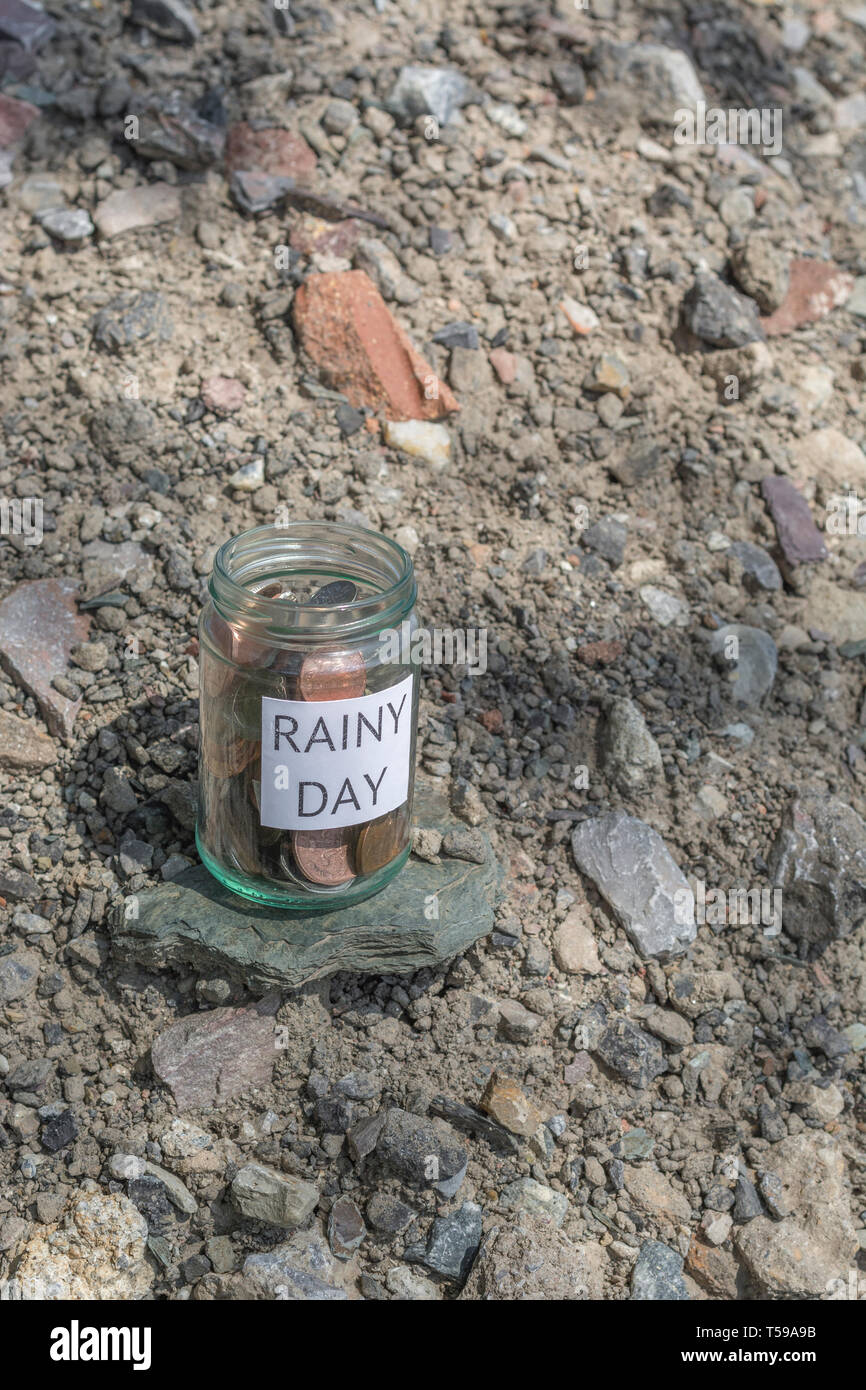 Geld jar/regnerischen Tag Einsparungen jar im Freien bei Sonnenschein. Metapher persönlichen Ersparnissen, Geld sparen, Vorsorge, Altersvorsorge, Speichern pot Stockfoto