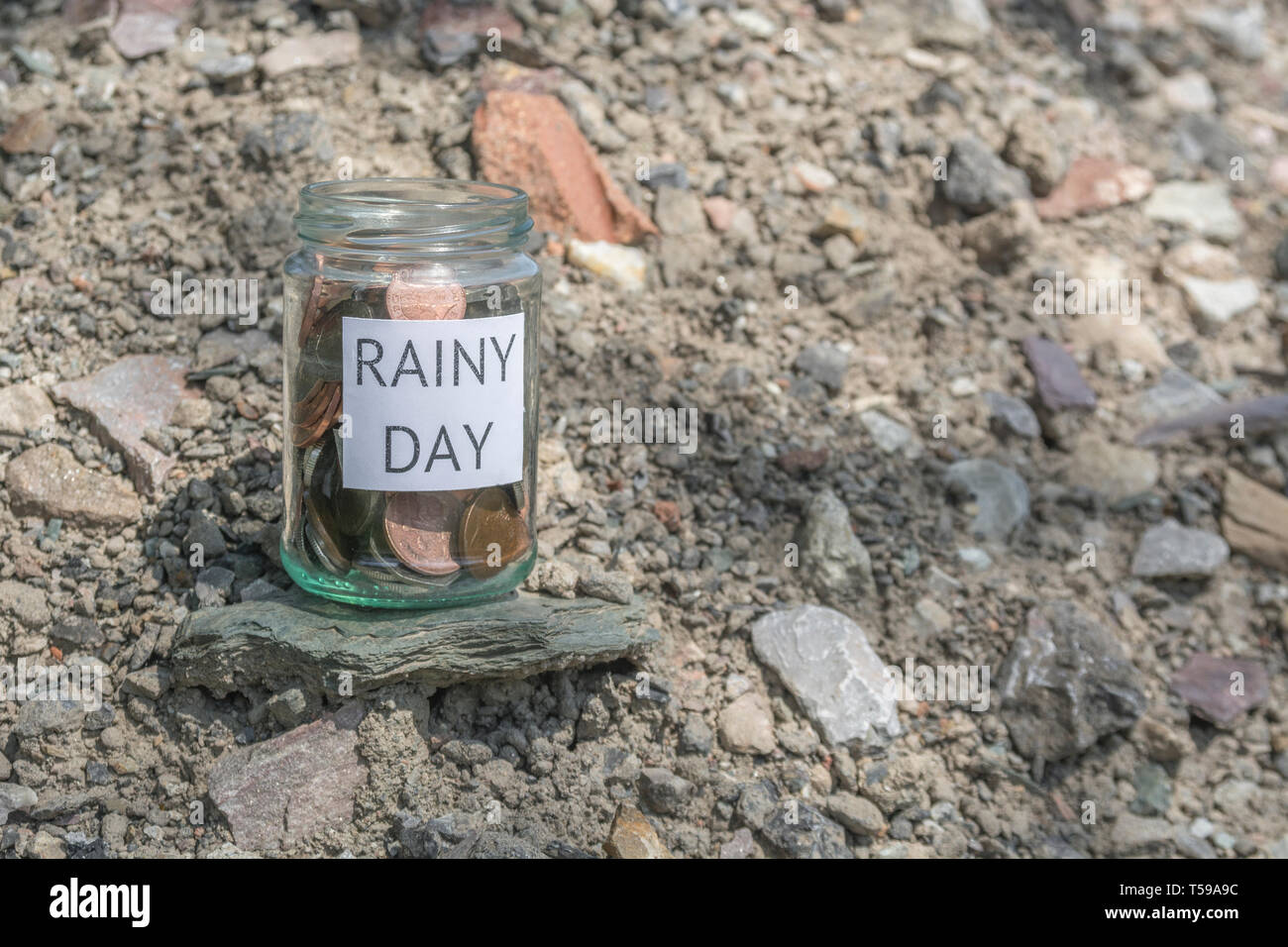 Geld jar/regnerischen Tag Einsparungen jar im Freien bei Sonnenschein. Metapher persönlichen Ersparnissen, Geld sparen, Vorsorge, Altersvorsorge, Speichern pot Stockfoto