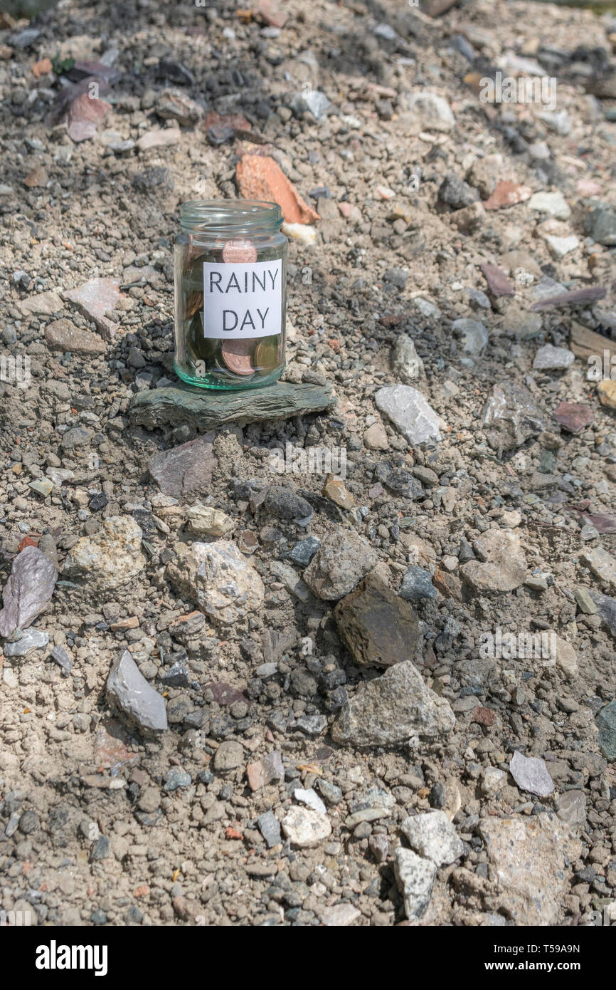 Geld jar/regnerischen Tag Einsparungen jar im Freien bei Sonnenschein. Metapher persönlichen Ersparnissen, Geld sparen, Vorsorge, Altersvorsorge, Speichern pot Stockfoto