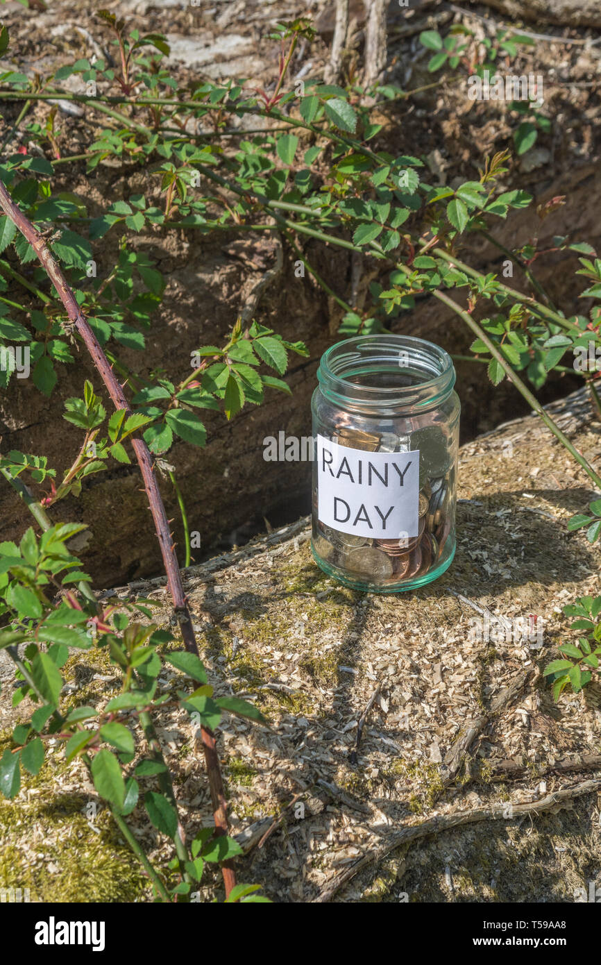 Geld jar/regnerischen Tag Einsparungen jar im Freien bei Sonnenschein. Metapher persönlichen Ersparnissen, Geld sparen, Vorsorge, Altersvorsorge, Speichern pot Stockfoto