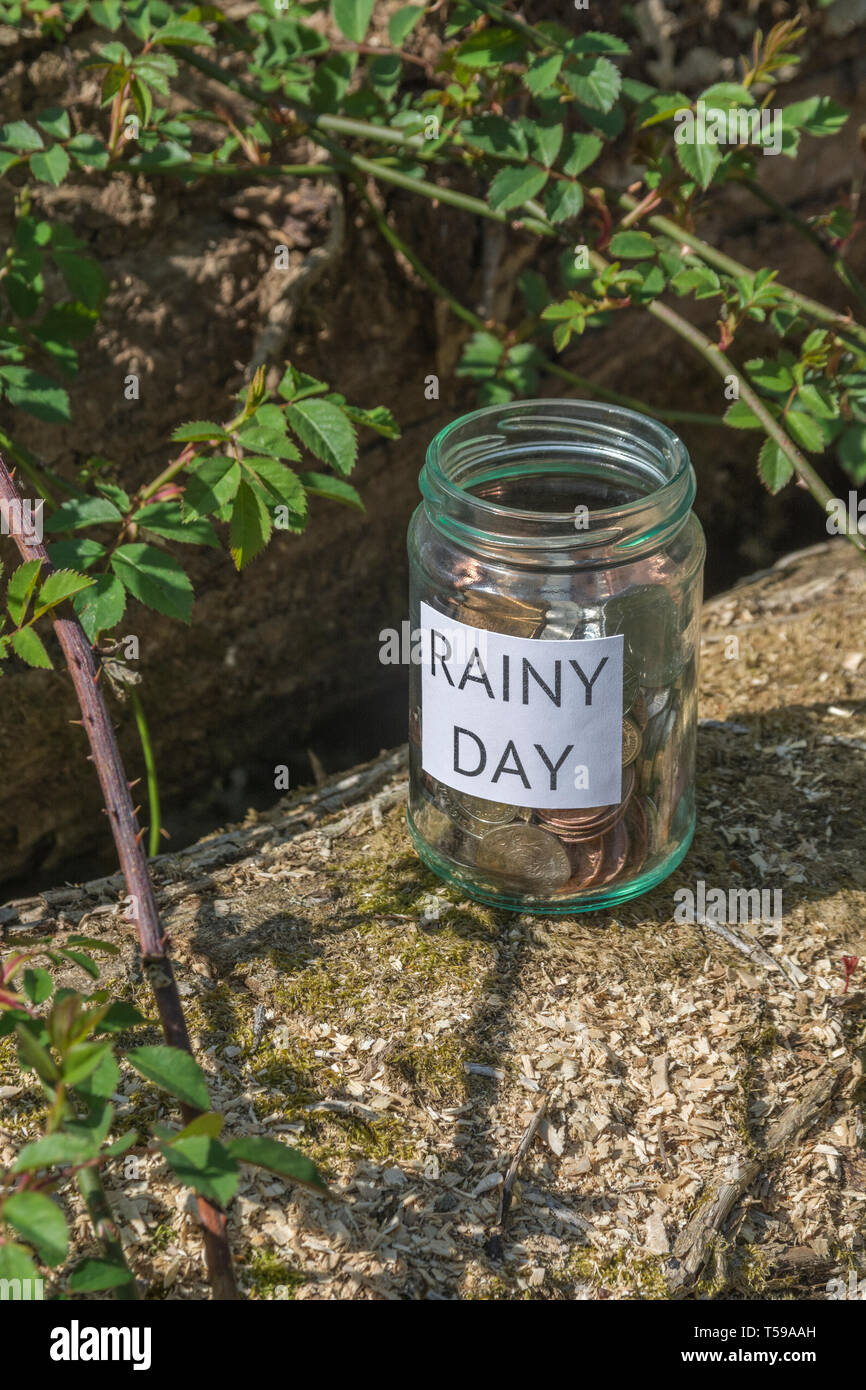 Geld jar/regnerischen Tag Einsparungen jar im Freien bei Sonnenschein. Metapher persönlichen Ersparnissen, Geld sparen, Vorsorge, Altersvorsorge, Speichern pot Stockfoto