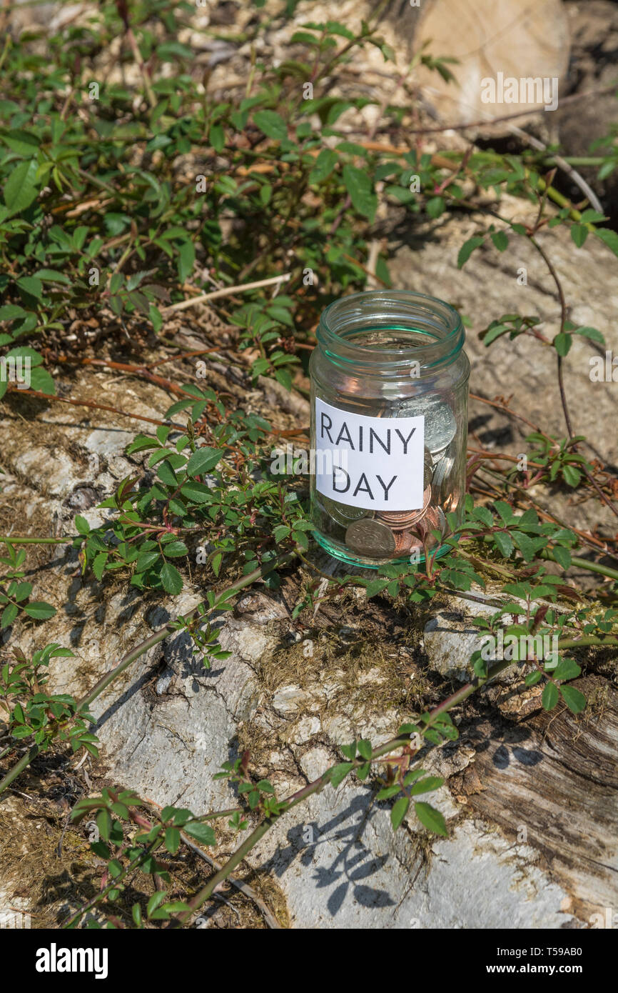 Geld jar/regnerischen Tag Einsparungen jar im Freien bei Sonnenschein. Metapher persönlichen Ersparnissen, Geld sparen, Vorsorge, Altersvorsorge, Speichern pot Stockfoto