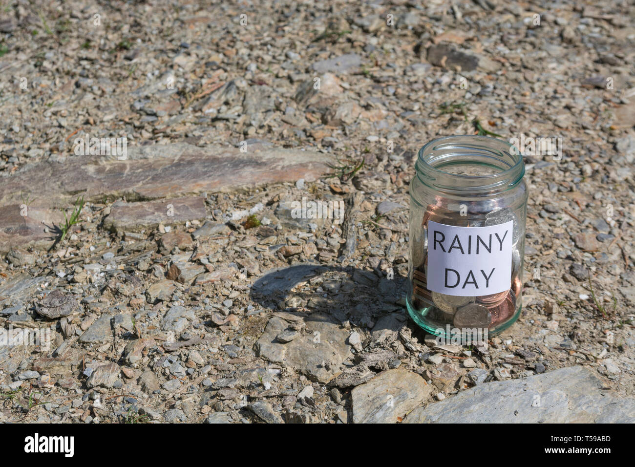 Geld jar/regnerischen Tag Einsparungen jar im Freien bei Sonnenschein. Metapher persönlichen Ersparnissen, Geld sparen, Vorsorge, Altersvorsorge, Speichern pot Stockfoto