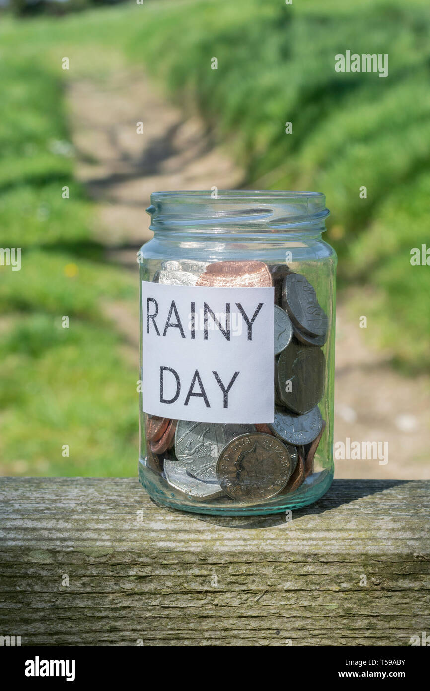 Geld jar/regnerischen Tag Einsparungen jar im Freien bei Sonnenschein. Metapher persönlichen Ersparnissen, Geld sparen, Vorsorge, Altersvorsorge, Speichern pot Stockfoto