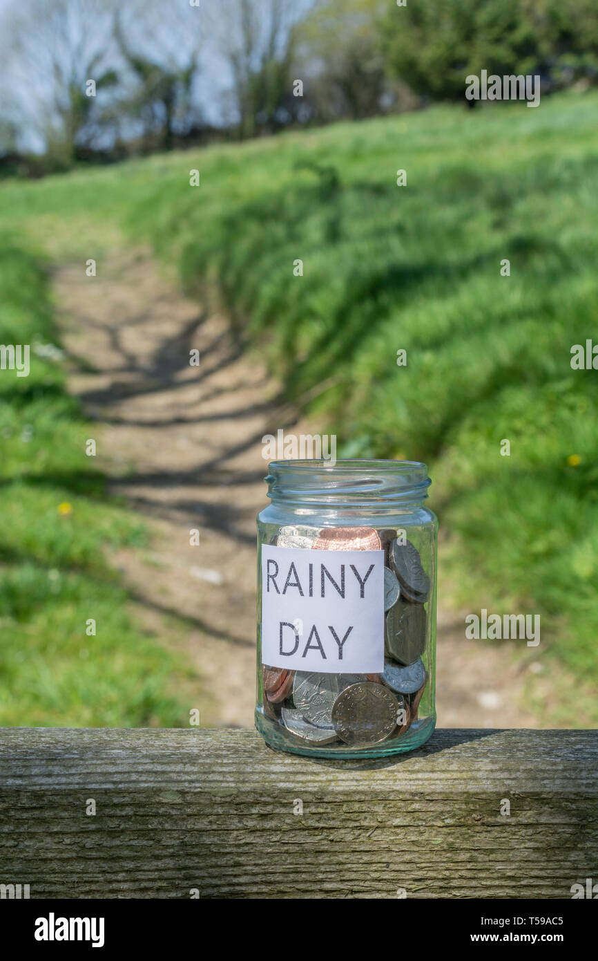 Geld jar/regnerischen Tag Einsparungen jar im Freien bei Sonnenschein. Metapher persönlichen Ersparnissen, Geld sparen, Vorsorge, Altersvorsorge, Speichern pot Stockfoto