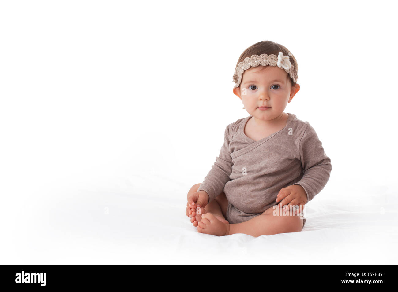 Adorable Baby Mädchen spielen mit seinen Beinen portrait Stockfoto