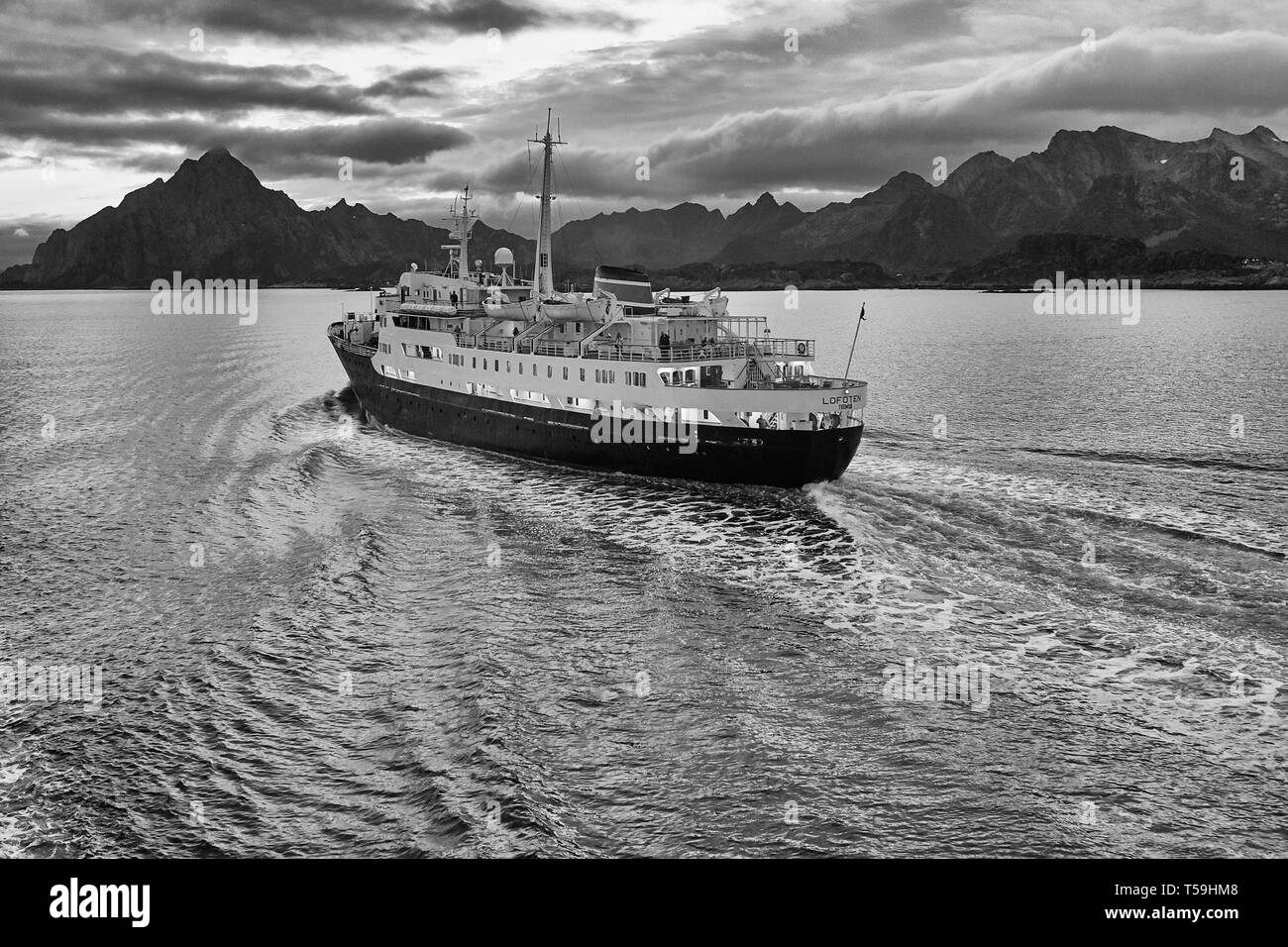 Schwarz-Weiß-Bild des Historischen Hurtigruten Schiff MS Lofoten, dampfende Southbound im Vestfjord, der schroffen Lofoten hinter sich. Norwegen. Stockfoto