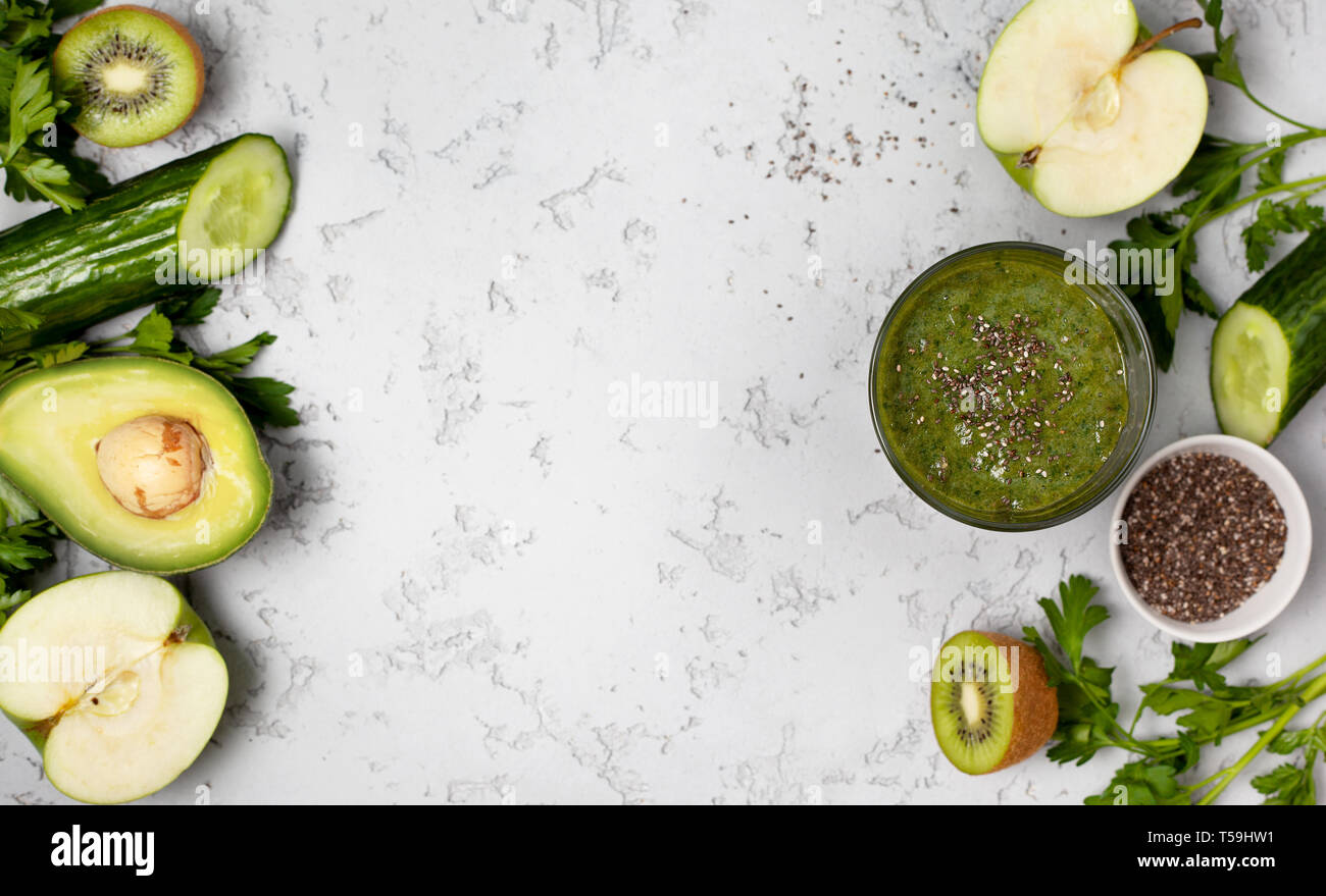 Grüne Smoothie in einem Glas, frisches Obst und Gemüse auf einem grauen Hintergrund. Blick von oben. Kopieren Sie Platz Stockfoto