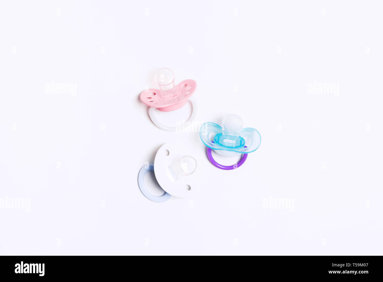 Drei farbenfrohe Baby Silikon Schnuller mit Halter in der Mitte auf weißem Hintergrund. Mock up. Flach. Ansicht von oben. Kieferorthopädische Geräte für Baby Stockfoto