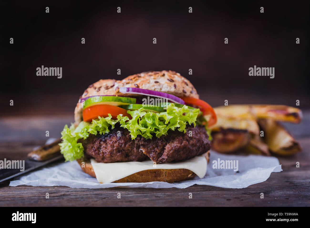 Hausgemachte Hamburger mit grünem Salat auf braunem Holz- Hintergrund. Stockfoto