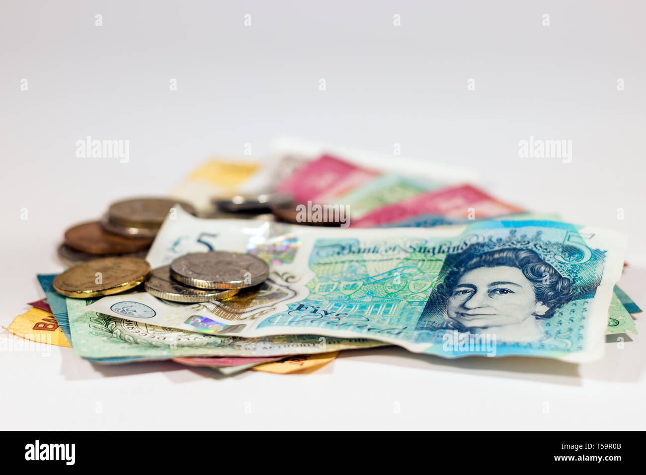 Fünf Pfund neue Polymer Banknote aus Großbritannien mit Münzen über Weiß. Stockfoto