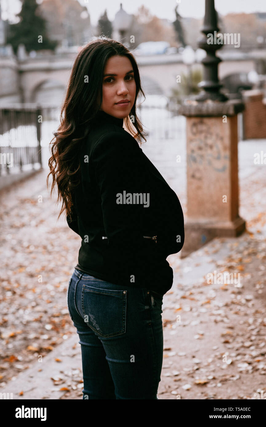 Schöne beleuchtete Hispanic Frau vor der Brücke im Winter Stockfoto