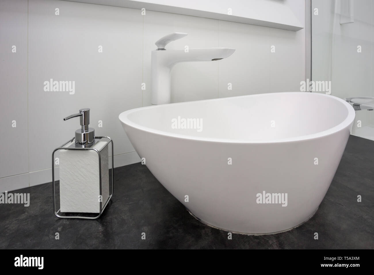 Seifen- und Shampoospender in der Nähe von keramischen Wasser Waschbecken mit Wasserhahn in teuren loft Bad tippen Stockfoto