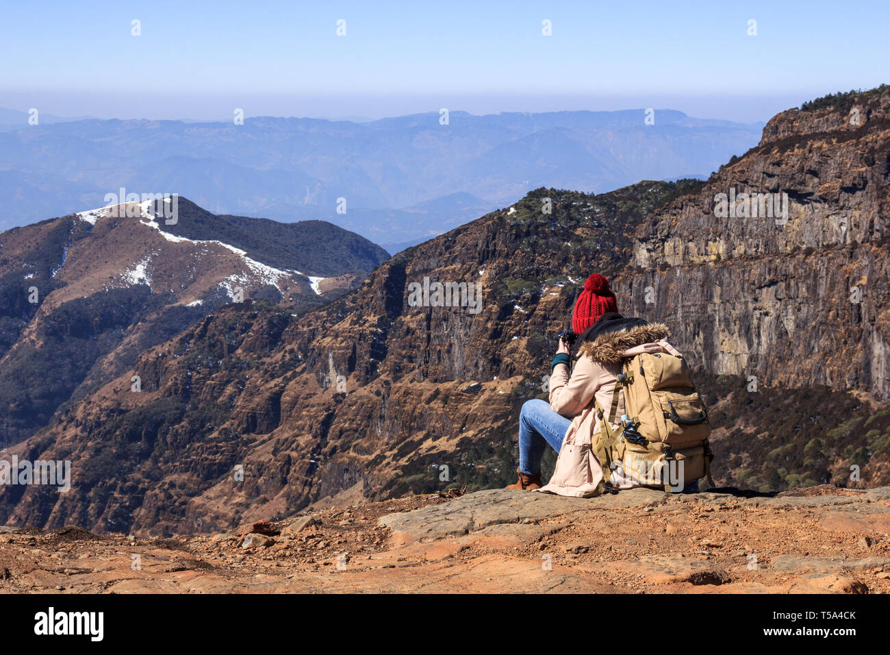 Mädchen Tourist befindet sich auf der Spitze eines Berges und bewundert die Ansicht Stockfoto