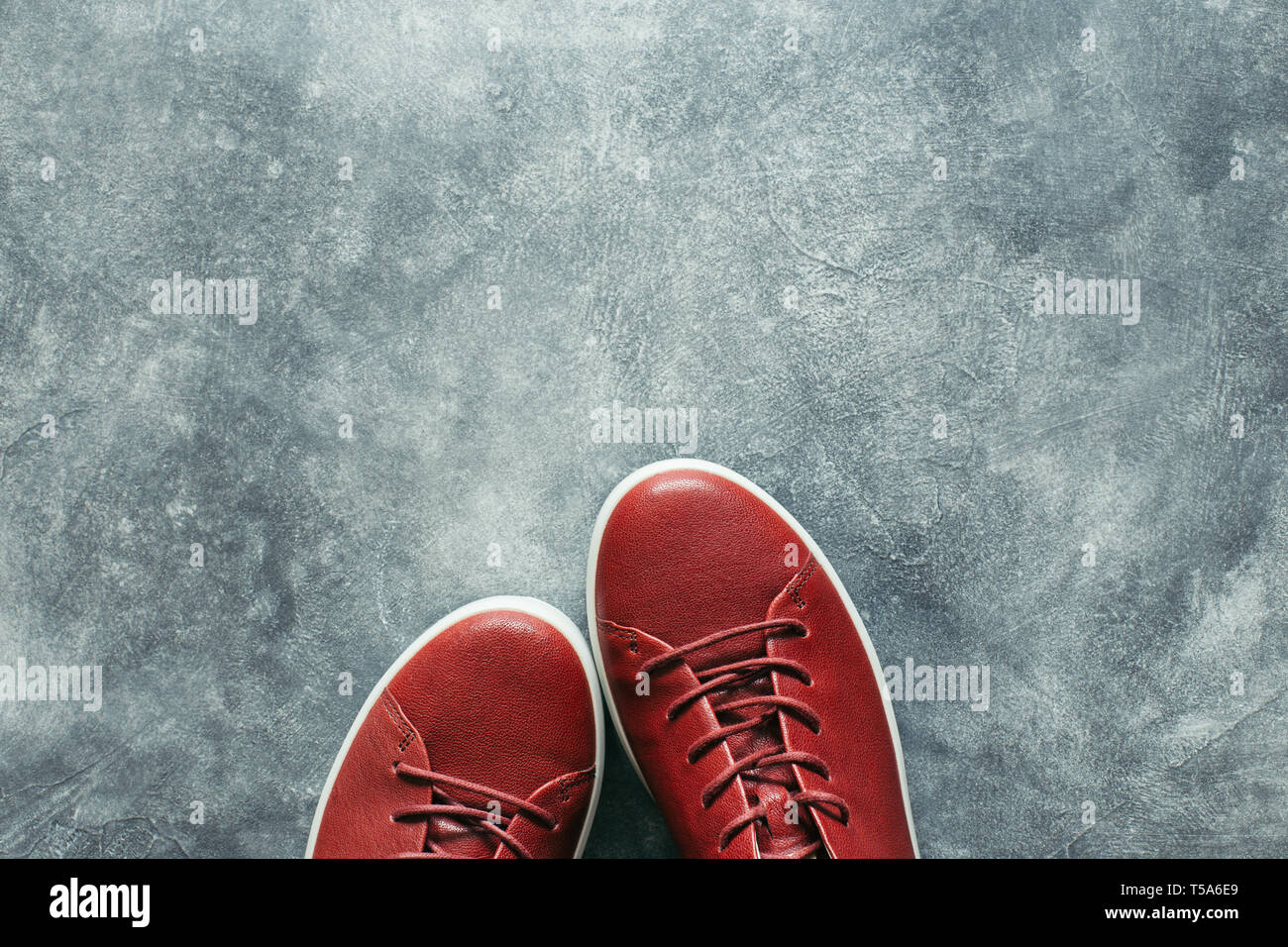 Woman Fashion terracotta Farbe Schuhe auf grauem Stein Hintergrund. Draufsicht auf rote Turnschuhe mit kopieren. Stockfoto