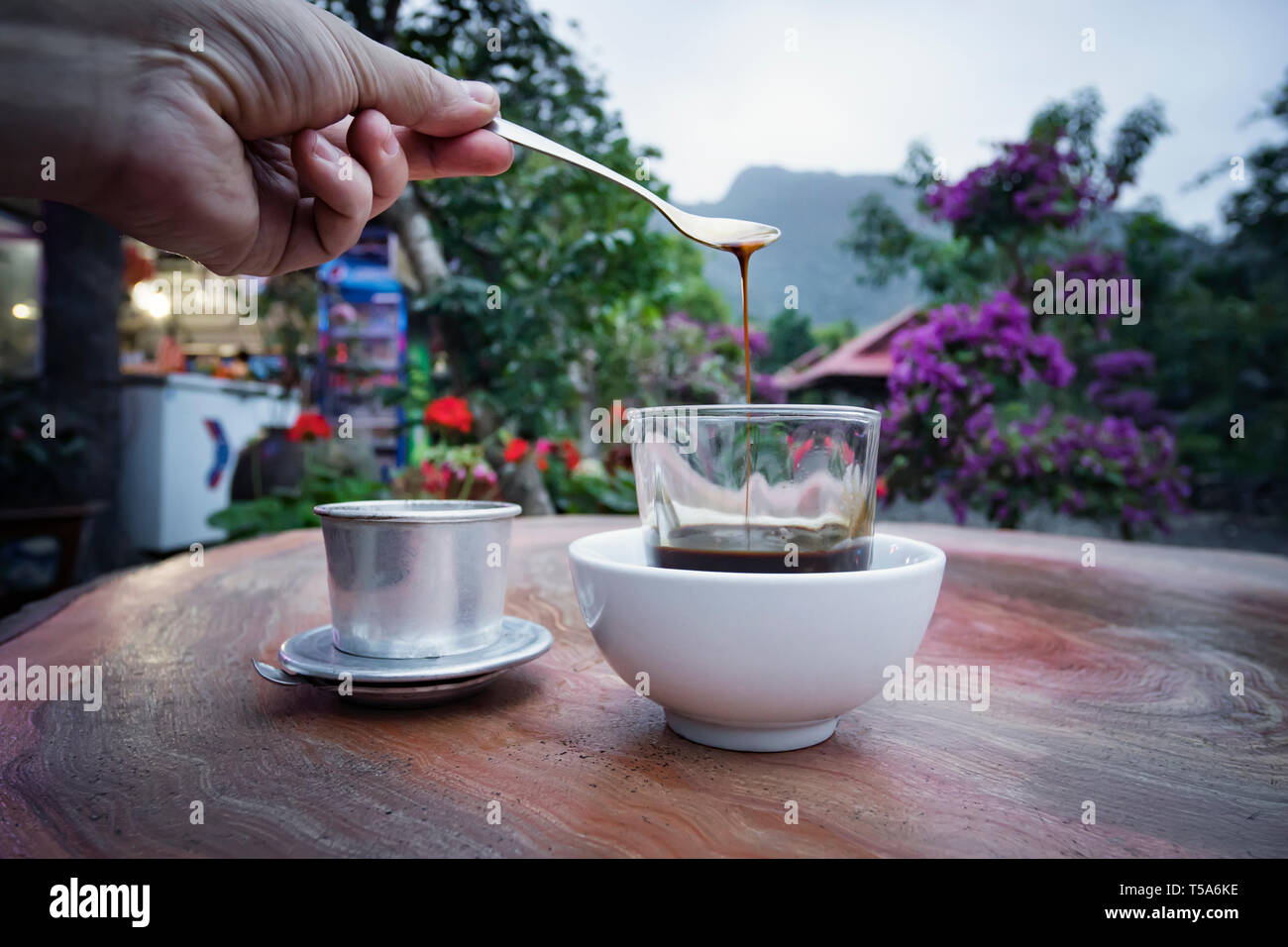 Milchkaffee Tasse morgens Frühstück auf Holztisch mit verschwommenen Berg Hintergrund. Selektive konzentrieren. Frühstück mit einer Tasse Kaffee in der Wunder Stockfoto