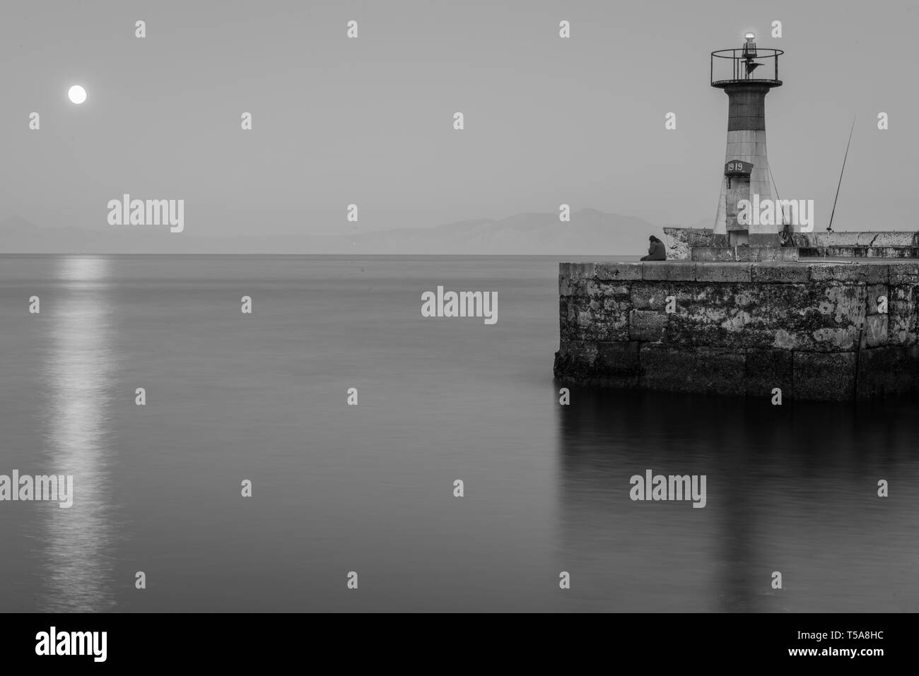 Die solar ein mondaufgang vom Eingang des Kalk Bay Hafen an der False Bay Küste in der südafrikanischen Provinz Western Cape Stockfoto