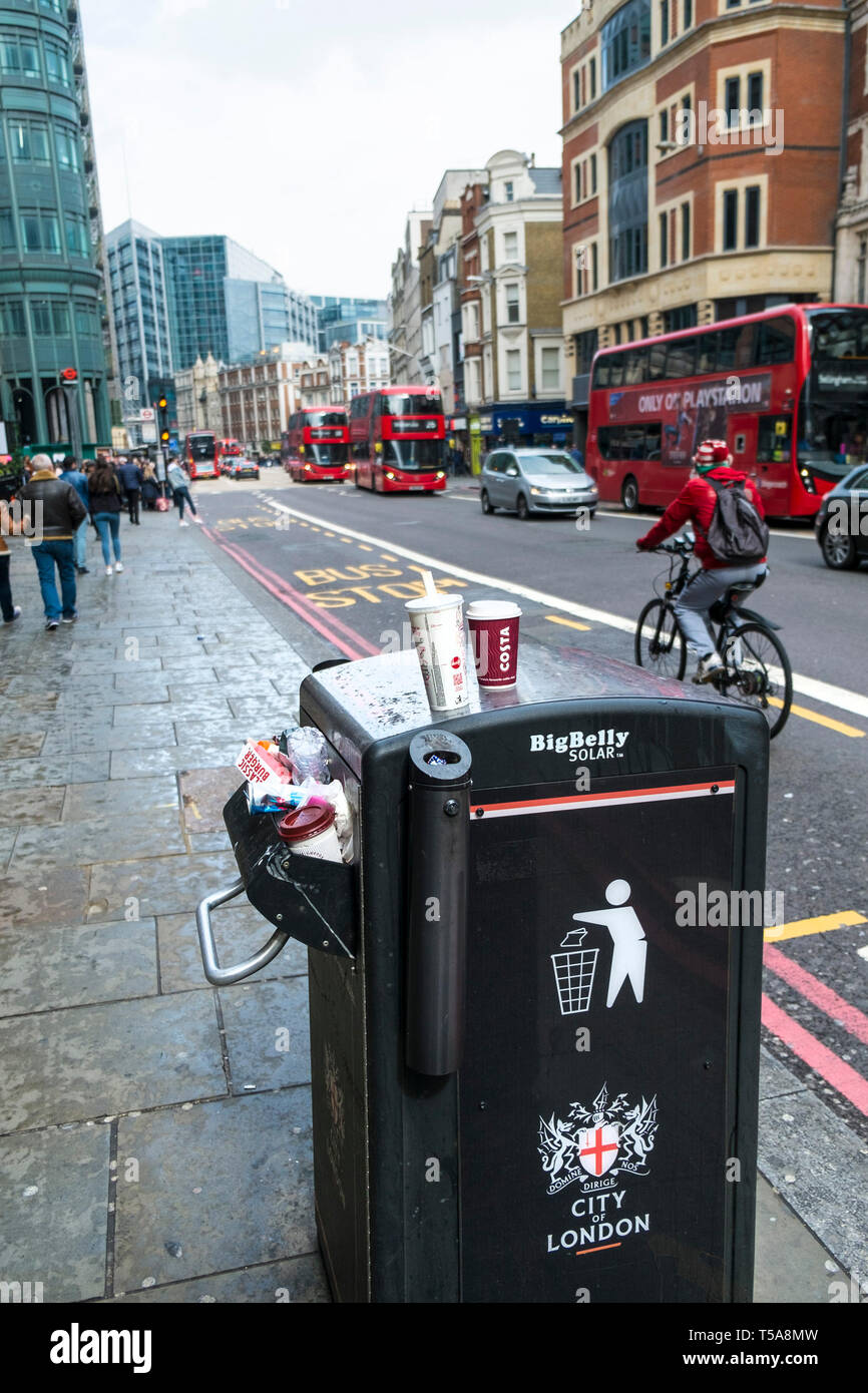 Ein großer Bauch Solar Abfallbehälter überfüllt mit Müll in der Stadt der London Street. Stockfoto