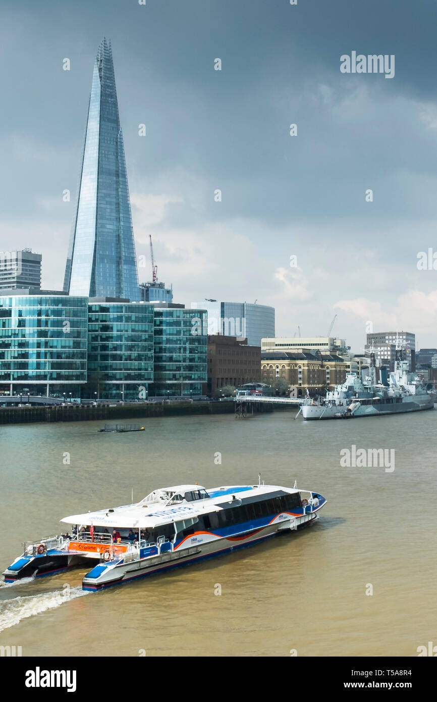 Ein Thames Clipper Schifffahrt auf der Themse mit dem Shard und anderen ikonischen Gebäude im Hintergrund. Stockfoto