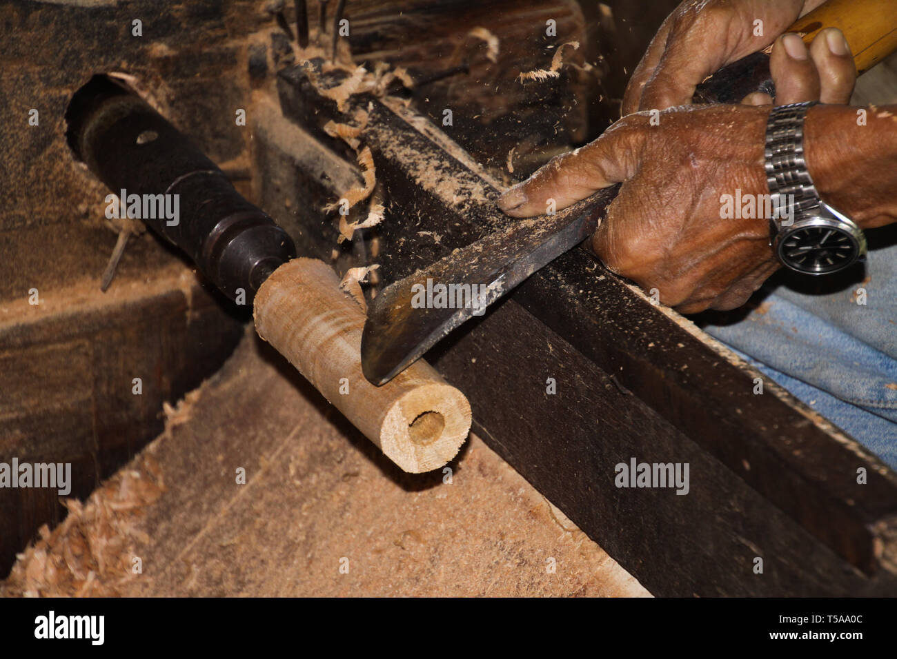 Hände von alten Arbeiter bilden ein Stück Bambus Holz mit Metall Werkzeug in einem Papier Regenschirm Factory in Chiang Mai Stockfoto