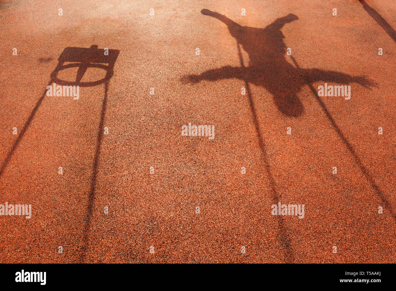 Schatten einer childs Schwingen auf die Gummiabdeckung Stockfoto