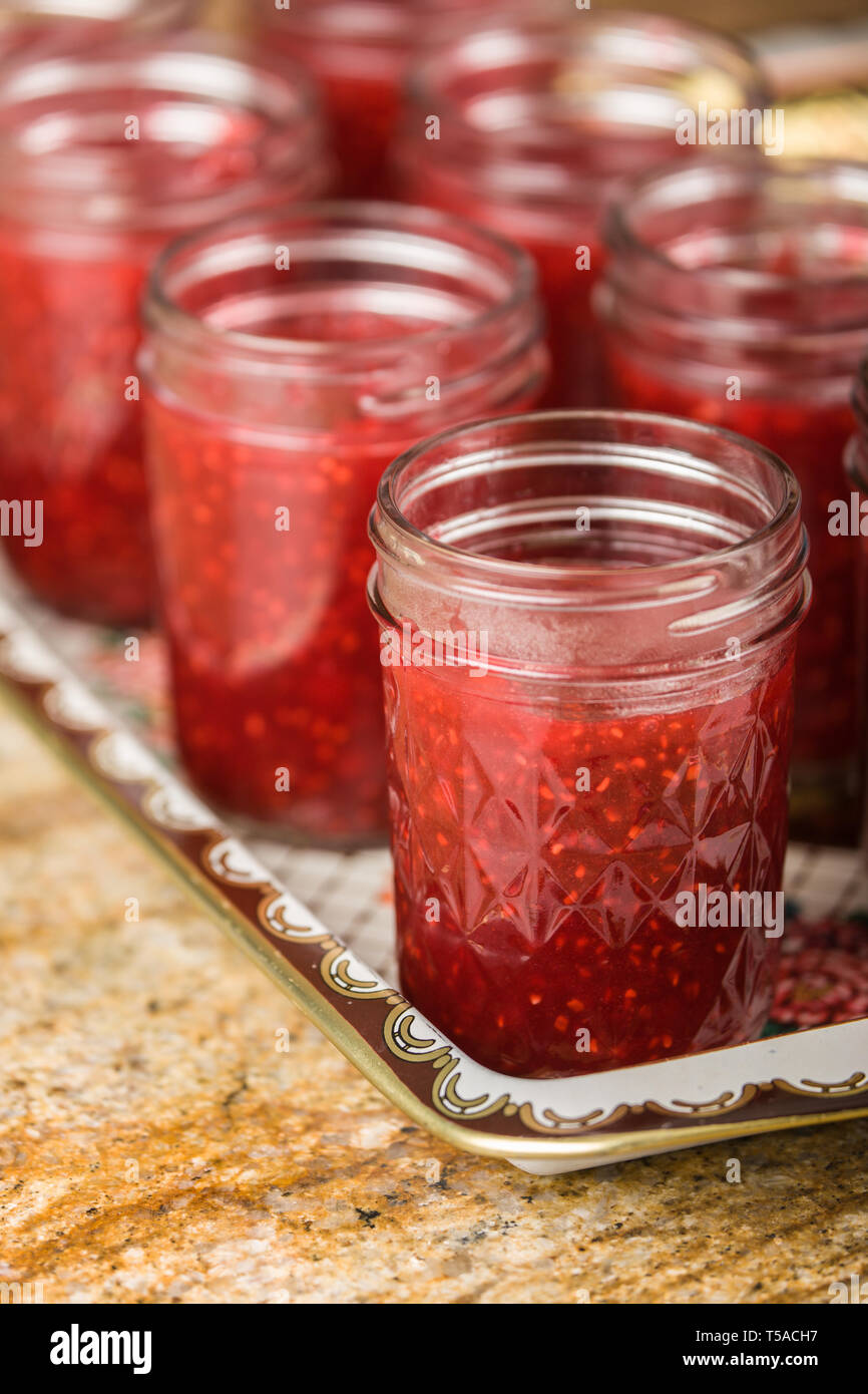 Gläser mit Himbeer Konfitüre gefüllt. Füllen Sie ihre Erwartung (desinfiziert) Gläser sofort innerhalb von 1/2 Zoll tops vor Inbetriebnahme Deckel auf Ihnen. (PR) Stockfoto