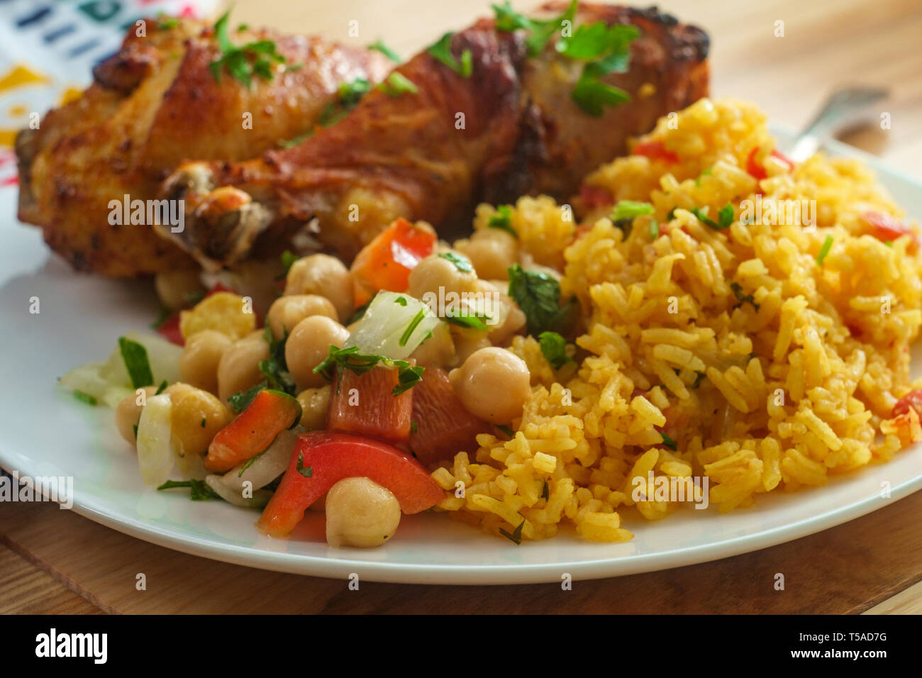 Portugiesische piri piri Hähnchen mit Kichererbsen Salat und gelber Reis Stockfoto