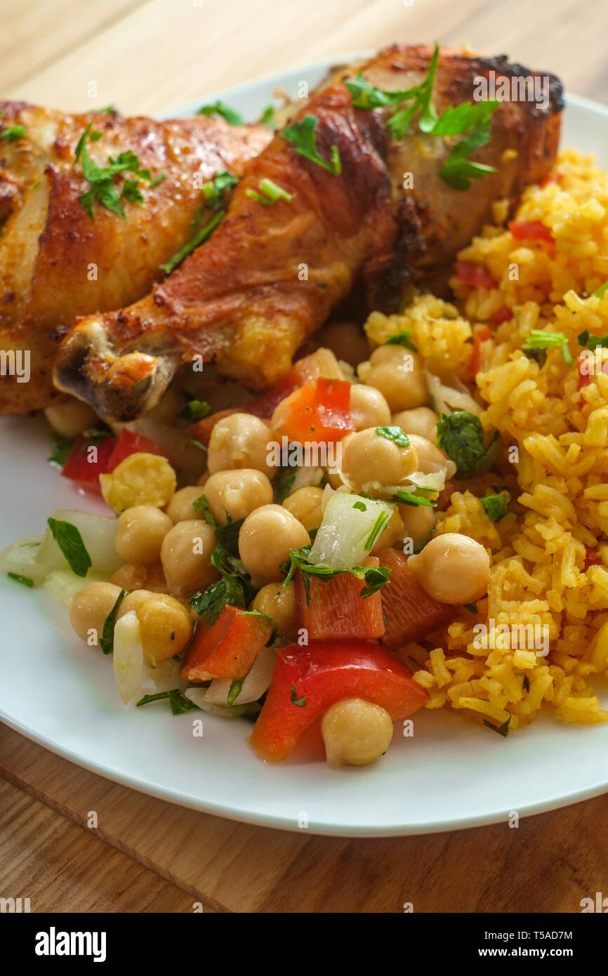 Portugiesische piri piri Hähnchen mit Kichererbsen Salat und gelber Reis Stockfoto