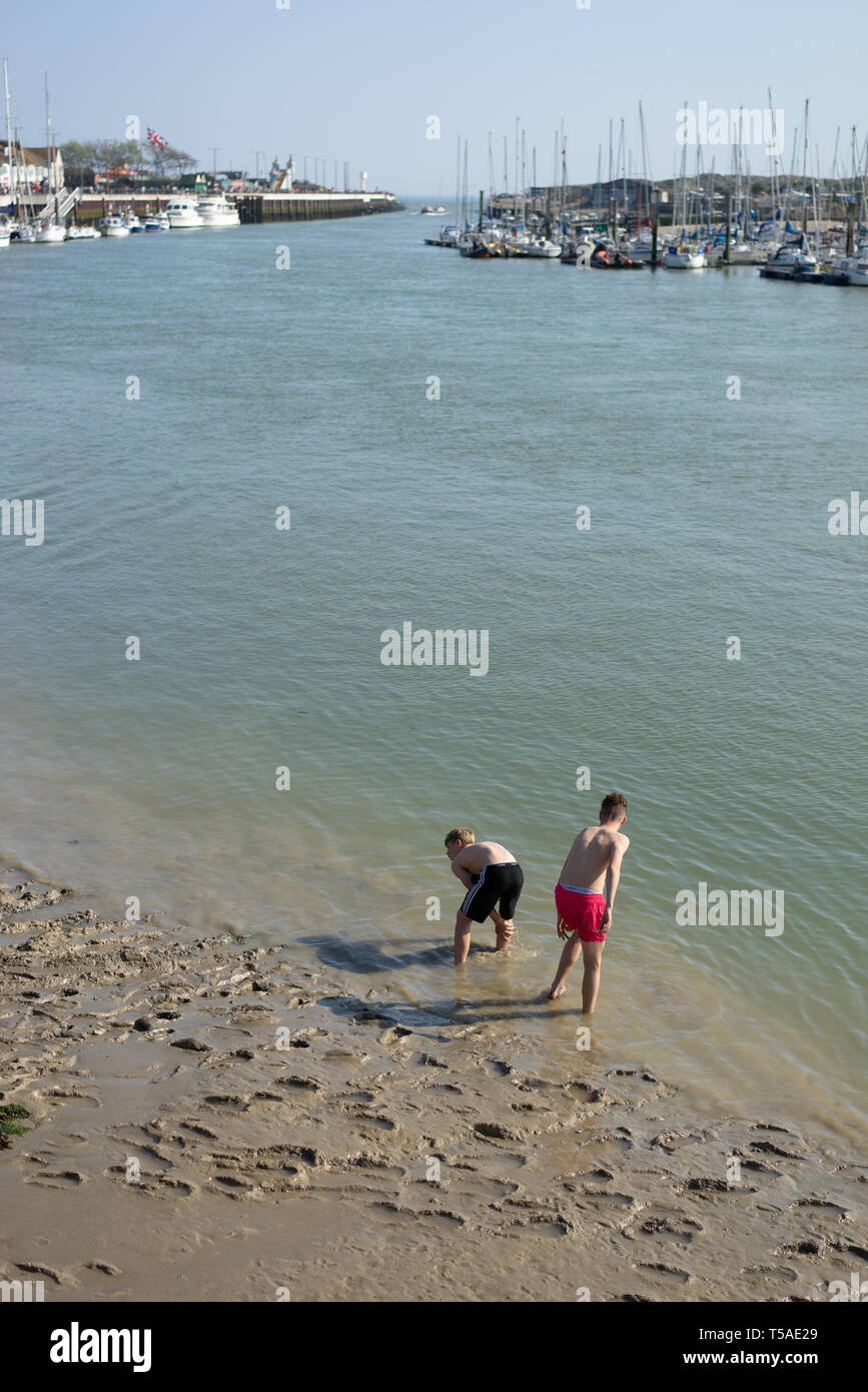 Zwei männliche Jugendliche in Badeshorts eintauchen, ihre Zehen im Wasser Stockfoto