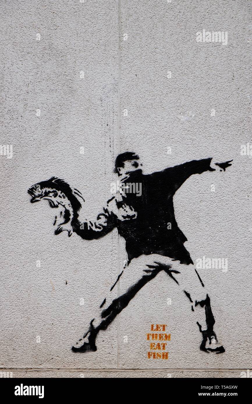 Die ikonischen Banksy Graffiti, "lassen Sie sie essen Fisch" an der Wand der Fischhändler, Hafen von Brixham. Stockfoto