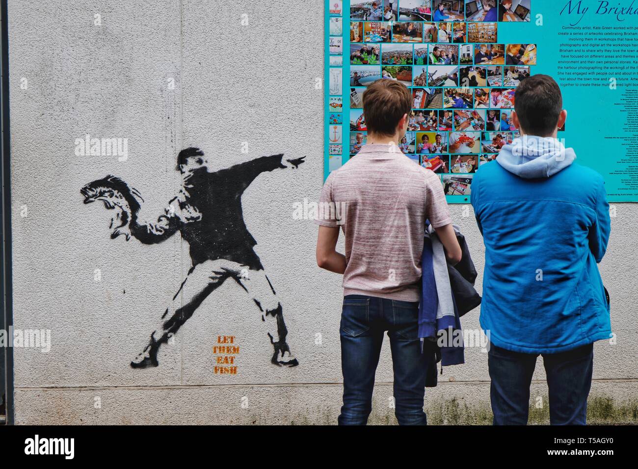 Die ikonischen Banksy Graffiti, "lassen Sie sie essen Fisch" an der Wand der Fischhändler, Hafen von Brixham. Stockfoto