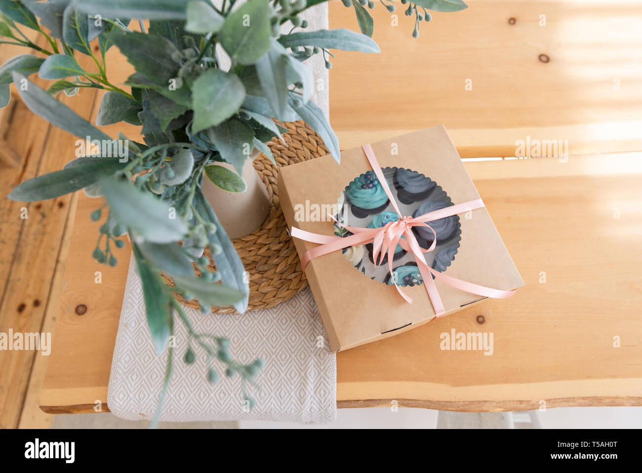Cupcake Verpackungen auf Holztisch, Lieferung, Vanille Cupcakes mit blauen und weißen Creme. Ansicht von oben, kopieren Platz für Text Stockfoto