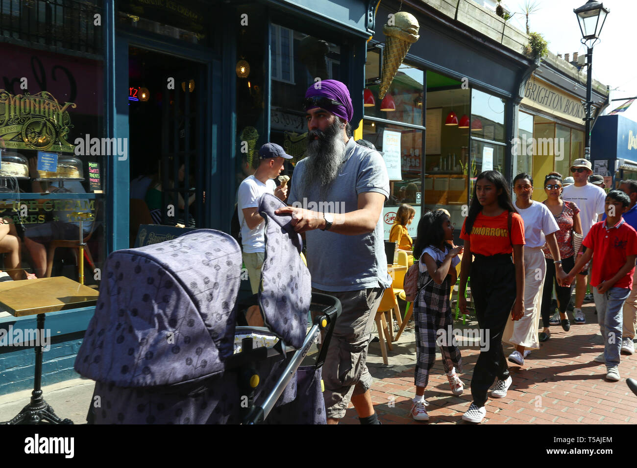 Sikh Mann mit einem Kinderwagen auf der Straße von Brighton. Stockfoto